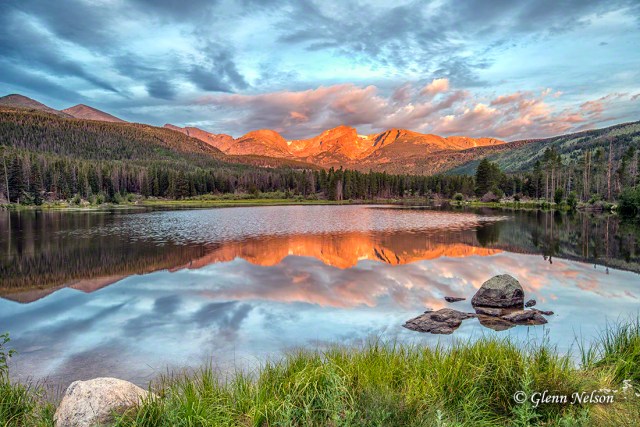 The rising sun gaves an orange glow to the peaks on the opposite side of Sprague Lake.