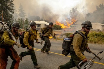 Firefighters flee as the Twisp River fire advances unexpectedly near Twisp, Washington, August 20, 2015. (Reuters/David Ryder)